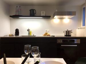 uma cozinha com dois copos de vinho numa mesa em VIADUKT Apartments em Zurique