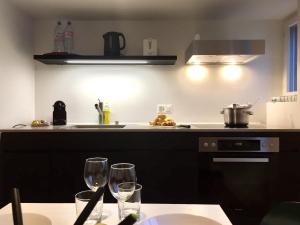 a kitchen with two wine glasses on a table at VIADUKT Apartments in Zürich