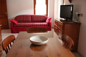 salon ze stołem i czerwoną kanapą w obiekcie Maison Chante Lune w mieście Introd