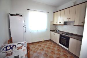 Una cocina con un refrigerador blanco y una ventana. en Casa Fariña, en Muxía