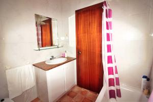 Un baño con lavabo y puerta de madera. en Casa Fariña, en Muxía 15 fotos más