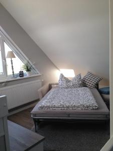 um quarto com uma cama com almofadas em Gemütliche Ferienwohnung im Luftkurort em Albersdorf