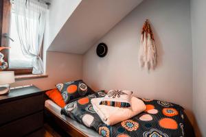a bedroom with a bed with a pillow on it at Podhale Agroturystyka u Mikołajki in Długopole