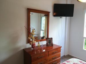 - une chambre avec une commode avec un miroir et une télévision dans l'établissement Apartamento en La Carihuela, à Torremolinos