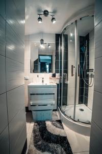 a bathroom with a sink and a shower with a mirror at Podhale Agroturystyka u Mikołajki in Długopole