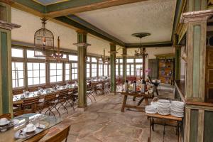 a dining room with tables and chairs and windows at Hotel Vila Relicário in Ouro Preto
