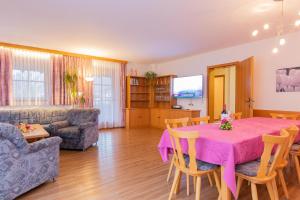 een woonkamer met een roze tafel en stoelen bij Ferienwohnungen Christine in Waidring