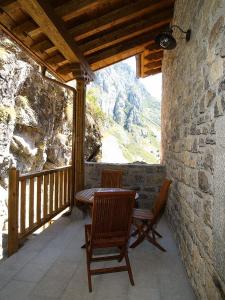 a patio with a table and chairs on a balcony at El Caleyon in Bulnes