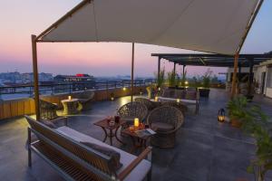 a rooftop patio with couches and tables on a building at Tsanga Tsanga Hotel in Antananarivo