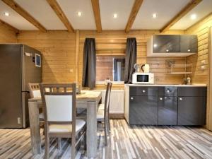 a kitchen and dining room with a table and chairs at Domki Kaper Rewa in Rewa