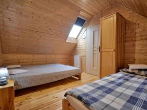 レバにあるDomki Kaper Rewaの木造キャビン内のベッドルーム1室(ベッド2台付)