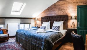 ein Schlafzimmer mit einem großen Bett mit Ziegelwand in der Unterkunft Hotel Telč in Telč
