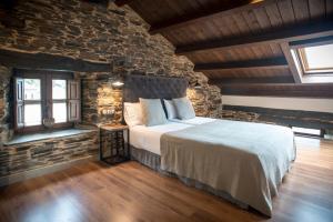 Un dormitorio con una cama y una pared de ladrillo. en Aldea Rural y Gastro Restaurante Casona de Labrada, en Labrada
