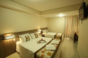 a hotel room with two beds and a tray of food at Paiaguas Palace Hotel in Cuiabá