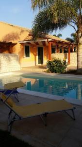 une piscine avec un banc à côté d'une maison dans l'établissement Villa Relax, à Donnalucata