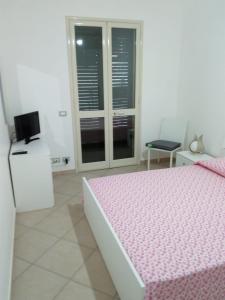 - une chambre avec un lit rose et une fenêtre dans l'établissement Villa Relax, à Donnalucata
