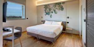 - une chambre avec un lit, un bureau et une fenêtre dans l'établissement Park Hotel & Residence by The Cube, à Fidenza