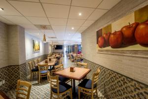 a restaurant with tables and chairs and a painting of apples at Oaxaca Inn Reforma in Oaxaca City