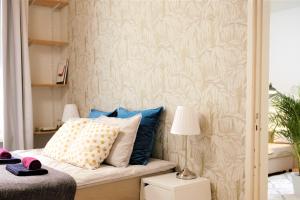 una camera da letto con letto con cuscini e parete di Stay Here Apartment Liisa a Helsinki