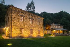 un gran edificio de ladrillo con luces en el césped en Aldea Rural y Gastro Restaurante Casona de Labrada, en Labrada