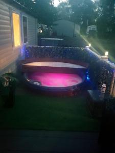 a hot tub in the yard of a house at night at 3 bedroom caravan with hot tub Tattershall lakes in Tattershall
