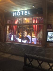 a hotel with a bench in front of a building at Hôtel Restaurant de la Chaussée in Briançon