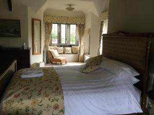 a bedroom with a large bed in a room with a window at Great House Guest House in Llantwit Major