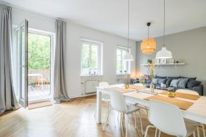 ein Esszimmer und ein Wohnzimmer mit einem weißen Tisch und Stühlen in der Unterkunft Eimsbütteler Straße "KUTTER" in Hamburg
