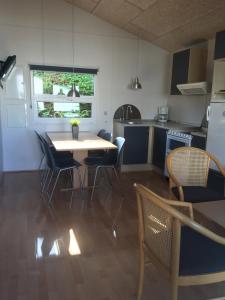 - une cuisine et une salle à manger avec une table et des chaises dans l'établissement First Camp Bøjden Strand, à Fåborg