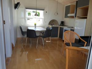 a kitchen with a table and chairs in a room at First Camp Bøjden Strand in Fåborg