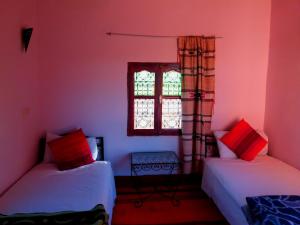 Habitación con 2 camas y ventana en Kasbah Les Nomades, en Skoura