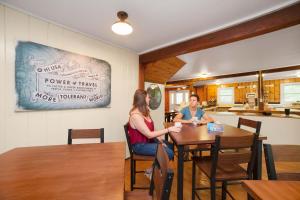 dos personas sentadas en una mesa en una cocina en HI - Martha's Vineyard Hostel, en Vineyard Haven