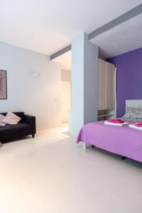 um quarto com duas camas e uma parede roxa em FV STUDIOS Chiaia em Nápoles