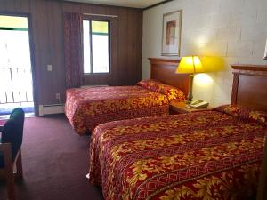 A bed or beds in a room at Granada Inn Motel - Kalkaska