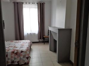 um pequeno quarto com uma cama e uma janela em Appart comme chez soi em Pusignan