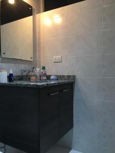 a bathroom with a black counter and a sink at EDIFICIO Samsara in Quito