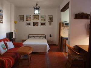 ein Wohnzimmer mit einem Bett und einem Sofa in der Unterkunft El Huerto de Lobras in Lobras