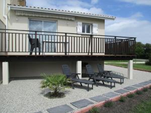un patio con sillas y una terraza con una casa en Logement Soulac sur mer, en Soulac-sur-Mer