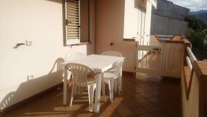 a white table and chairs on a balcony with a window at Villa Mary in Fluminimaggiore