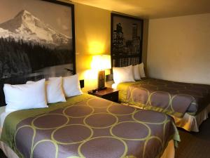 a hotel room with two beds and a picture on the wall at Super 8 by Wyndham Woodburn in Woodburn +19 photos