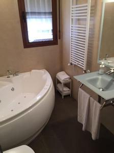 a bathroom with a sink and a toilet and a tub at El Amanecer de la Sierra in Casla