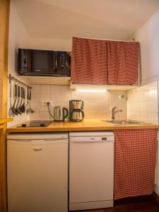 una pequeña cocina con encimera y fregadero en 26 Praz de l'Ours Vallandry - Paradiski, en Peisey-Nancroix
