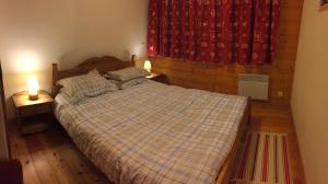 1 dormitorio con 1 cama con 2 lámparas y una ventana en appartement fogliettaz, en La Thuile Sainte-Foy-Tarentaise