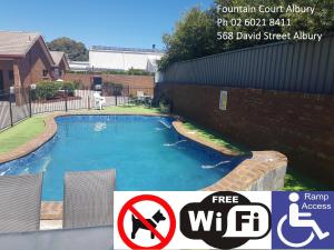 una señal para una piscina frente a una casa en Fountain Court Motor Inn Albury en Albury