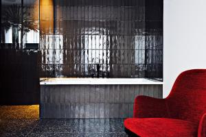 uma cadeira vermelha num quarto com uma janela em U Eat & Sleep Antwerp em Antuérpia