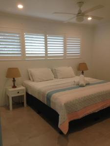 a bedroom with a bed with two lamps on it at Chez Noosa Resort Motel in Sunshine Beach