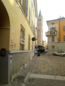 an empty street with a building and a car at Luisa in Palazzo Bianchi in Parma