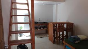 a room with a ladder and a kitchen with a table at Pousada Ilha do Campeche in Florianópolis