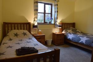 a bedroom with two twin beds and a window at Mowbray Stable Cottages in Thirsk