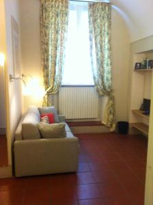 uma sala de estar com um sofá e uma janela em Luisa in Palazzo Bianchi em Parma